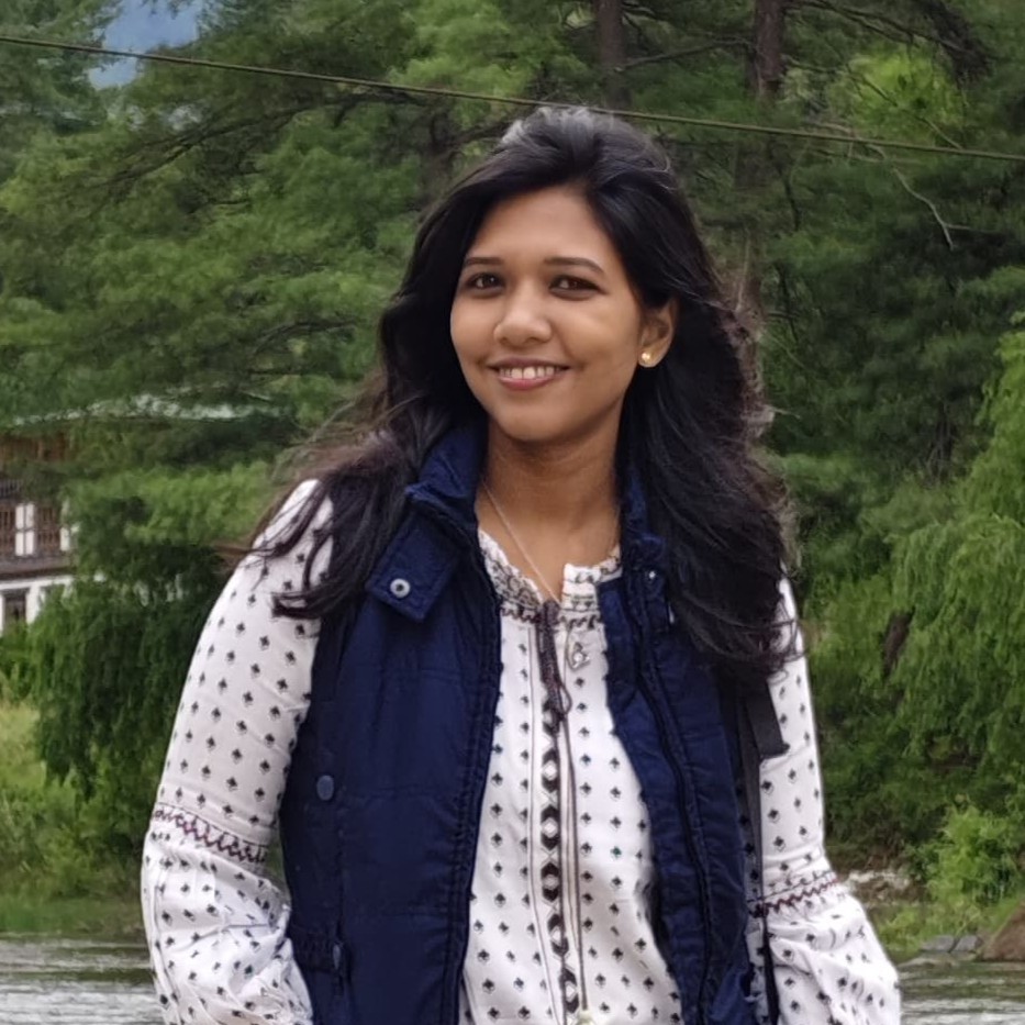 Portrait of Baishali smiling outdoors by a river